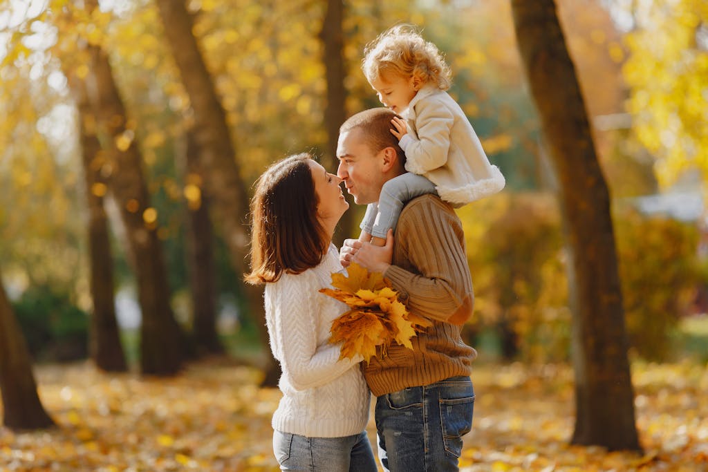 Happy family hugging in autumn park